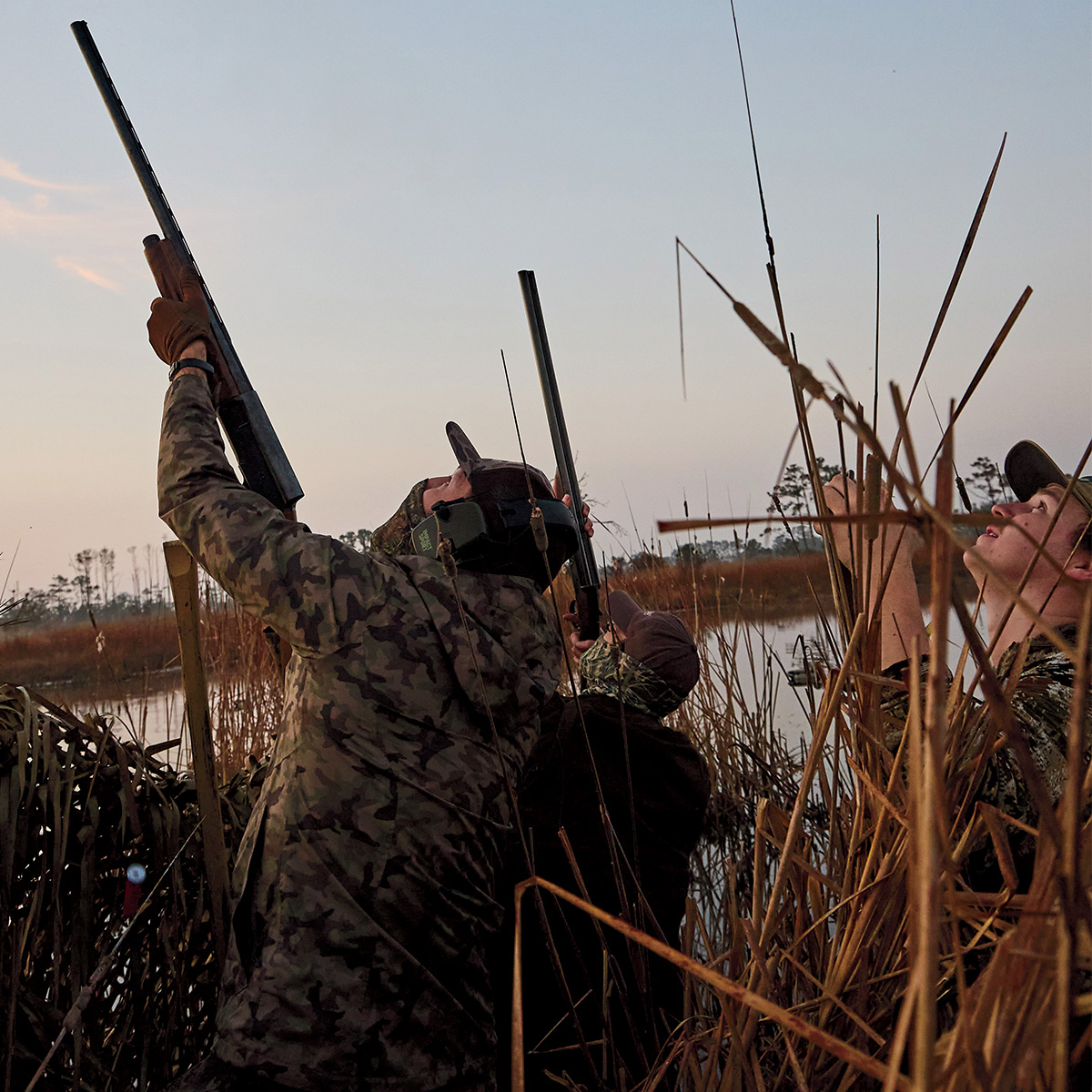 (From left) Pete Klimek and the author take aim at incoming birds while Avery Williams looks on. Photo by Peter Frank Edwards